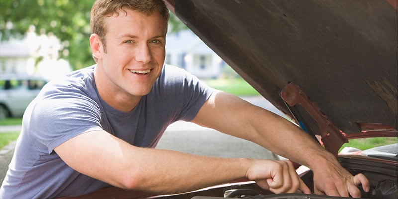 young man fixing his car's motor